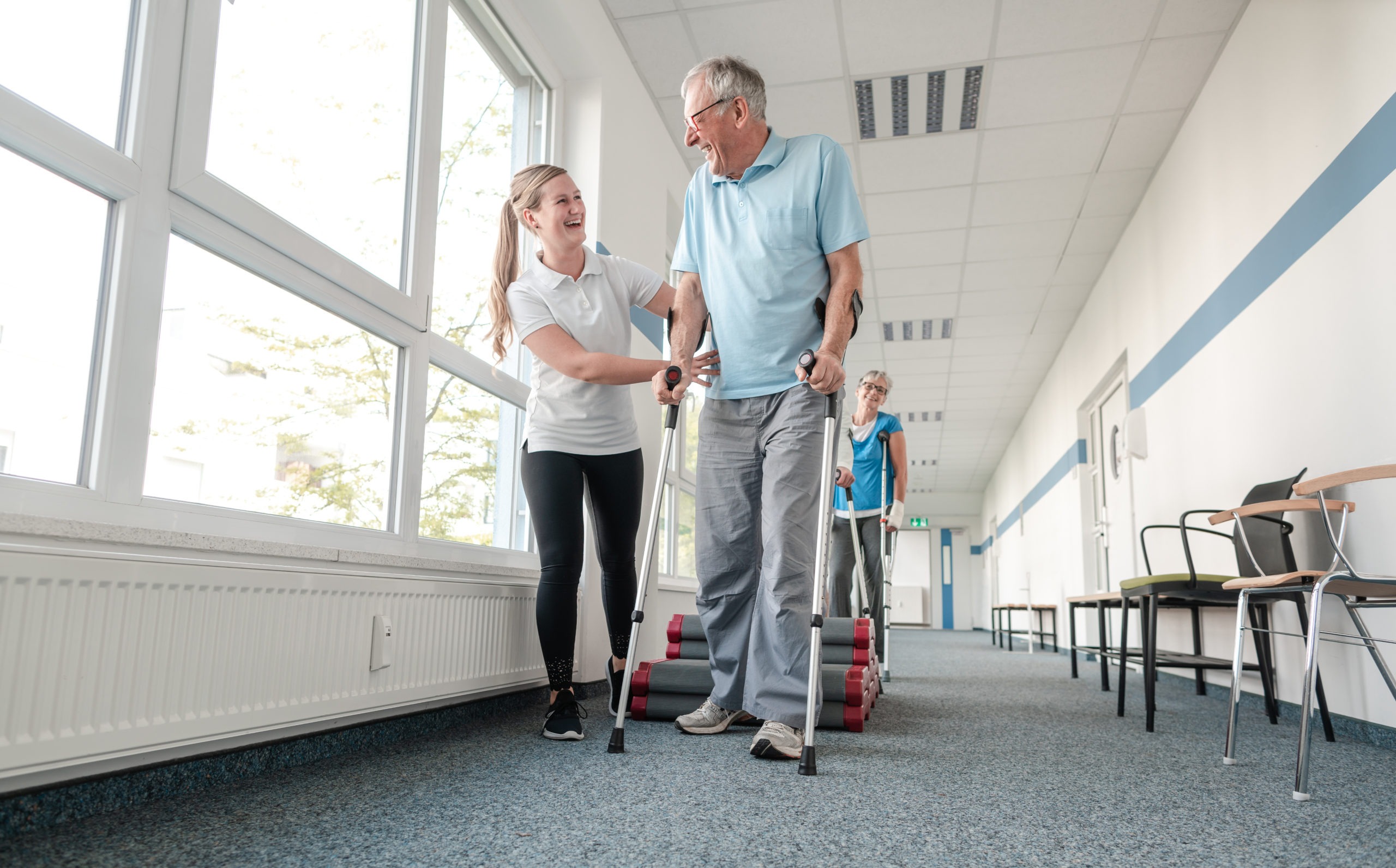 Seniors in rehabilitation learning how to walk with crutches after having had an injury