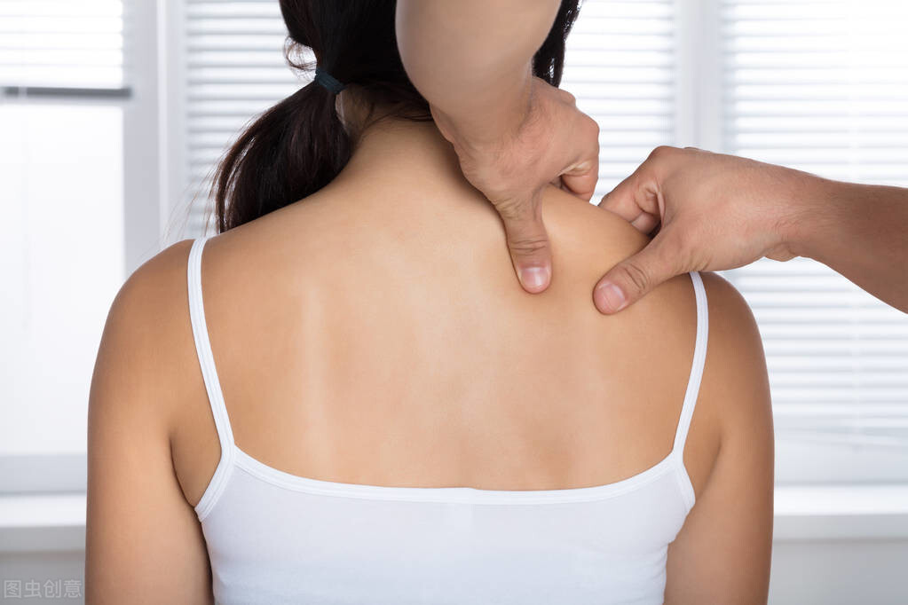 Rear View Of A Young Woman Receiving Shoulder Massage From Masseur