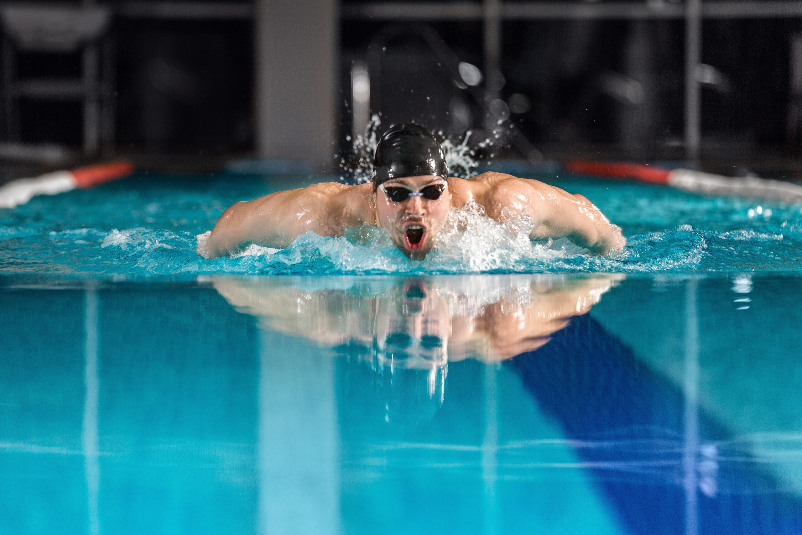 Young male swimmer swimming the butterfly stroke in a pool